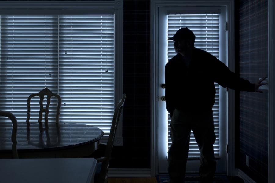 burglar in dark room flicking light switch
